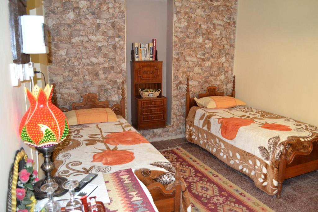 Twin room with stone wall and colourful bedspreads